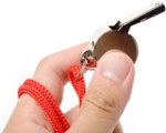 Picture of referee's hand holding a whistle